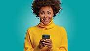 Woman smiling while holding cell phone Woman smiling while holding cell phone