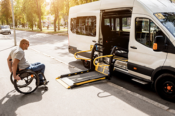 man in wheelchair getting into vehicle