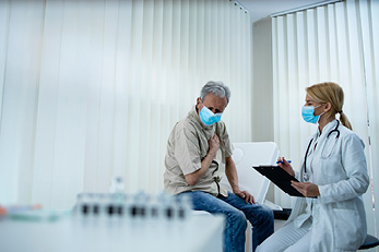 Paciente enmascarada hablando con la doctora