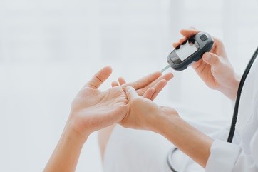 nurse using instrument on patient's finger