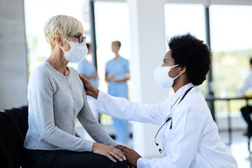 female doctor kneeling and talking to female patient