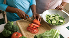 Women slicing vegatables on cutting board