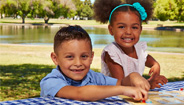 Two kids sitting at a table at the park Two kids sitting at a table at the park
