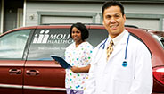Doctor and Nurse standing in front of Molina van